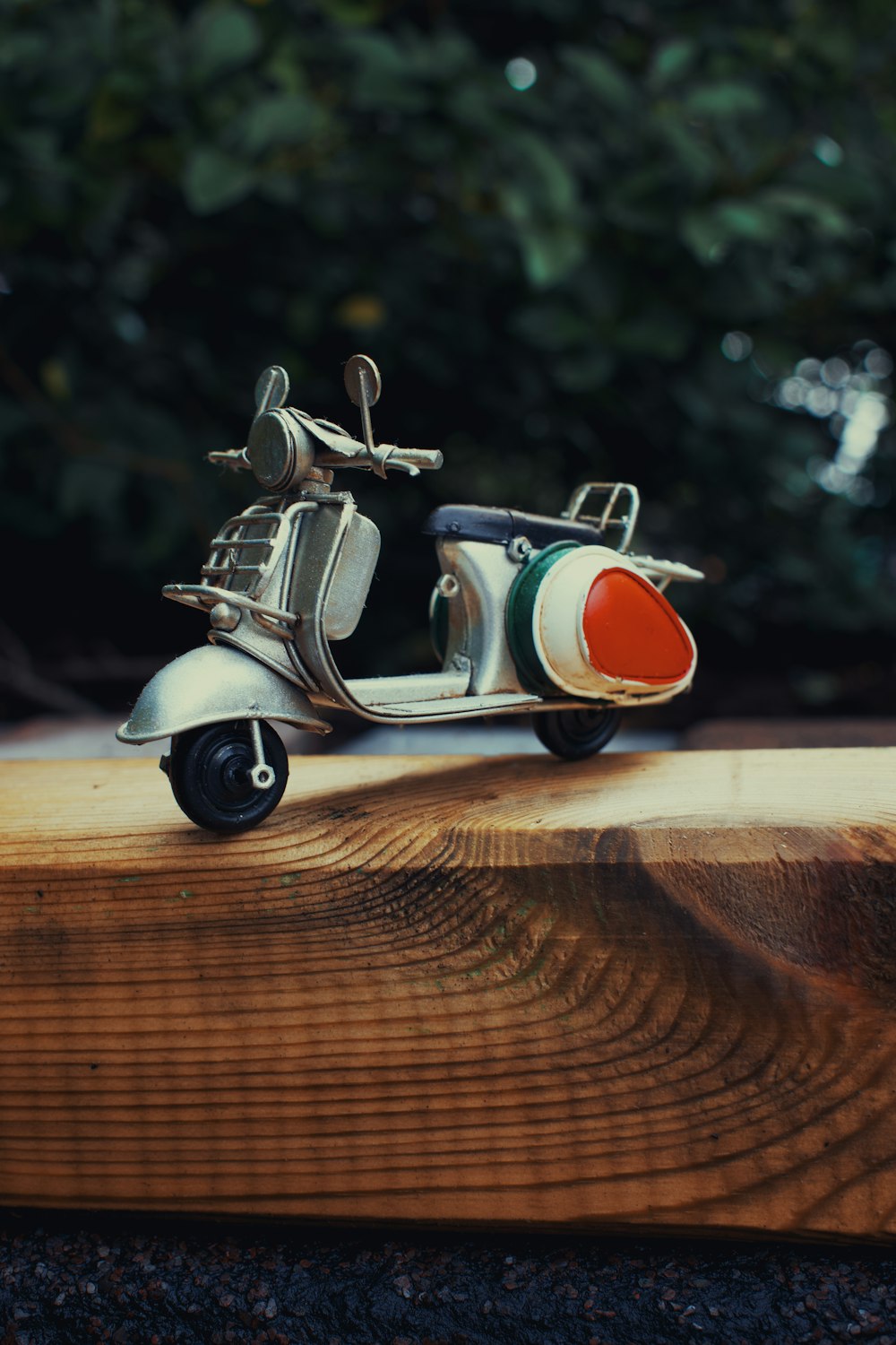 Un scooter de juguete sentado encima de una tabla de madera