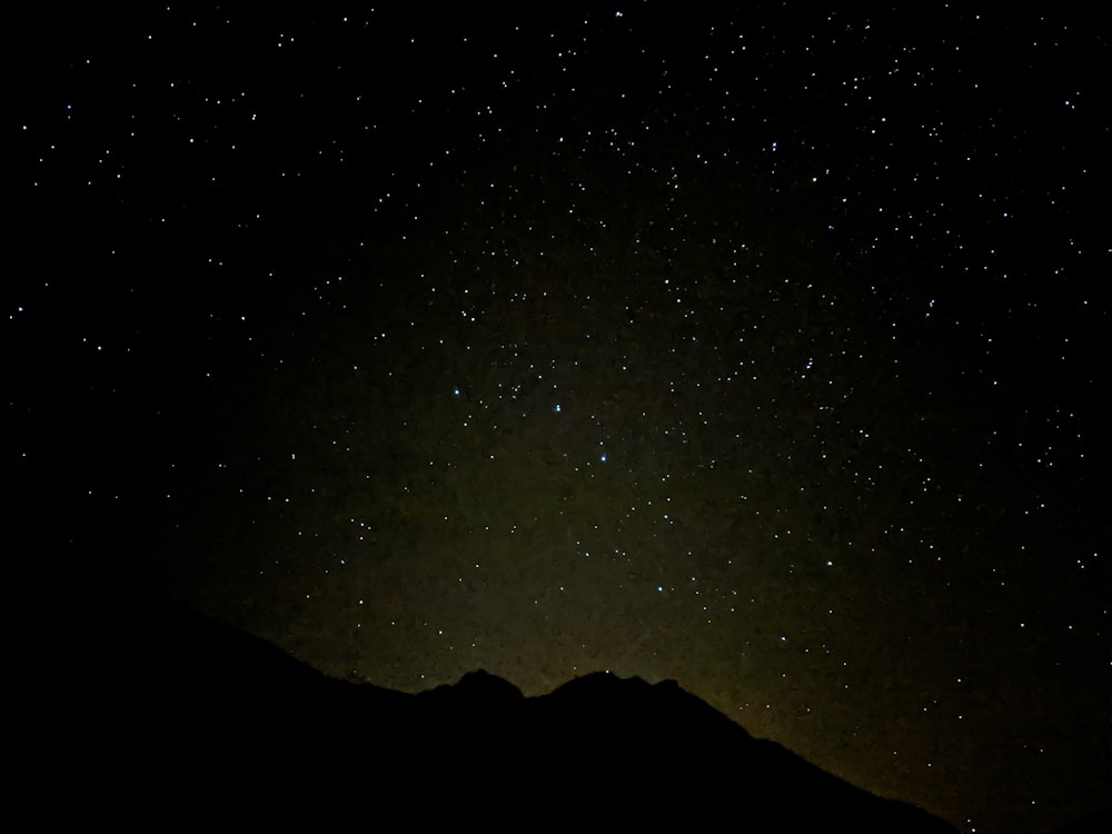 Il cielo notturno con le stelle sopra una catena montuosa