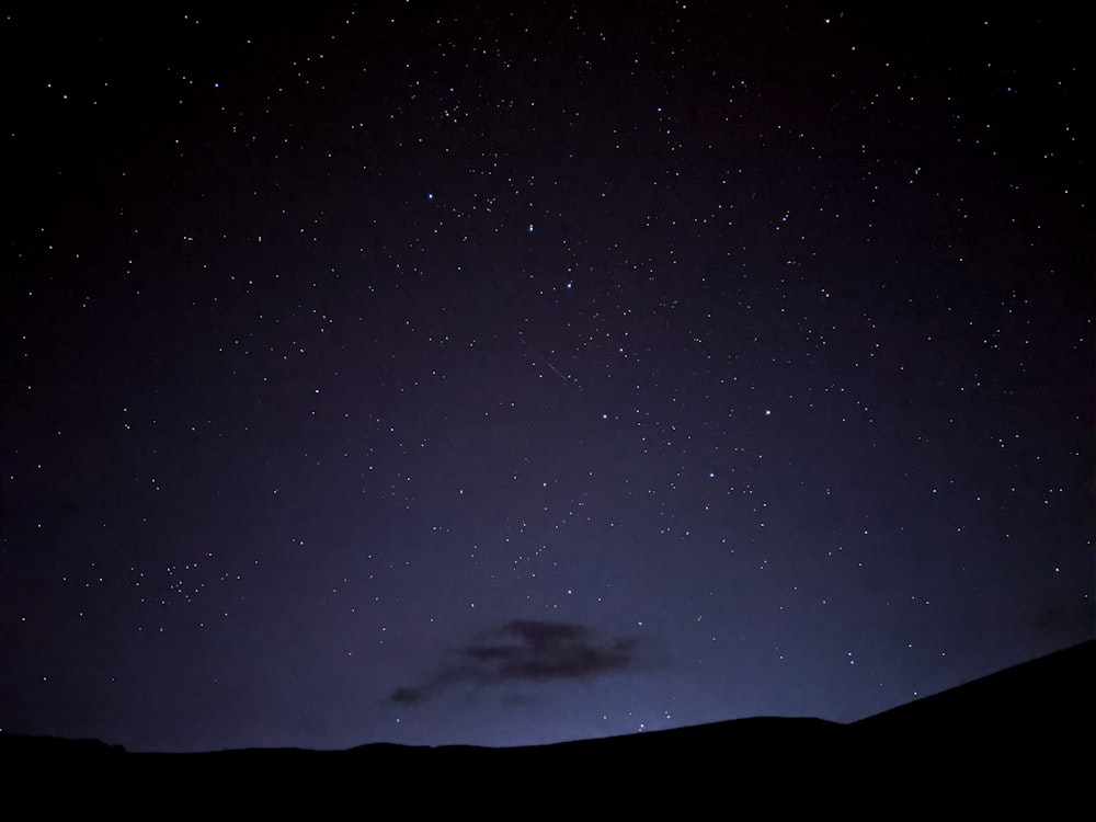 a night sky with stars and a few clouds