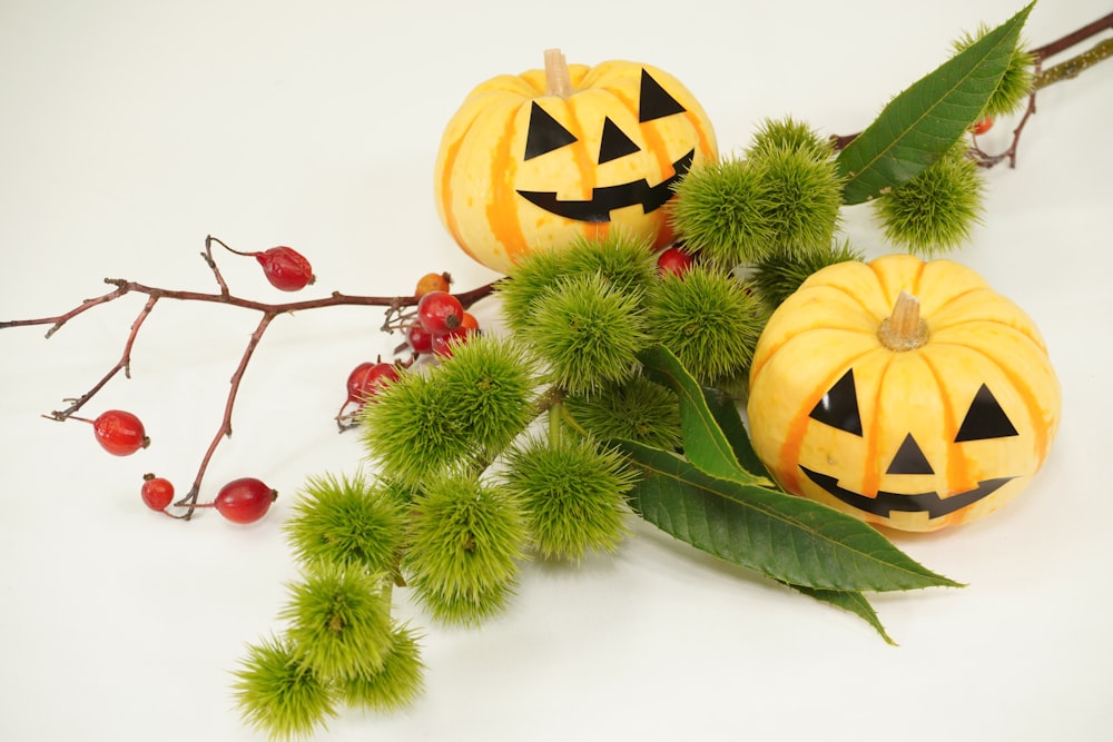 a couple of pumpkins sitting on top of a tree branch