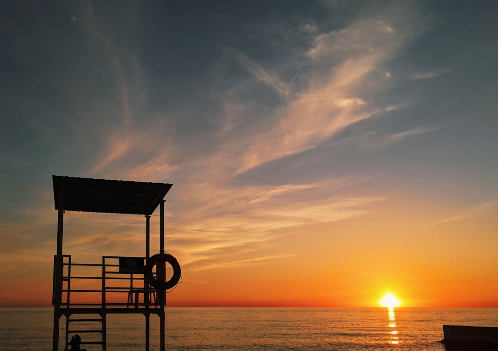 a lifeguard tower sitting on top of a beach next to the ocean