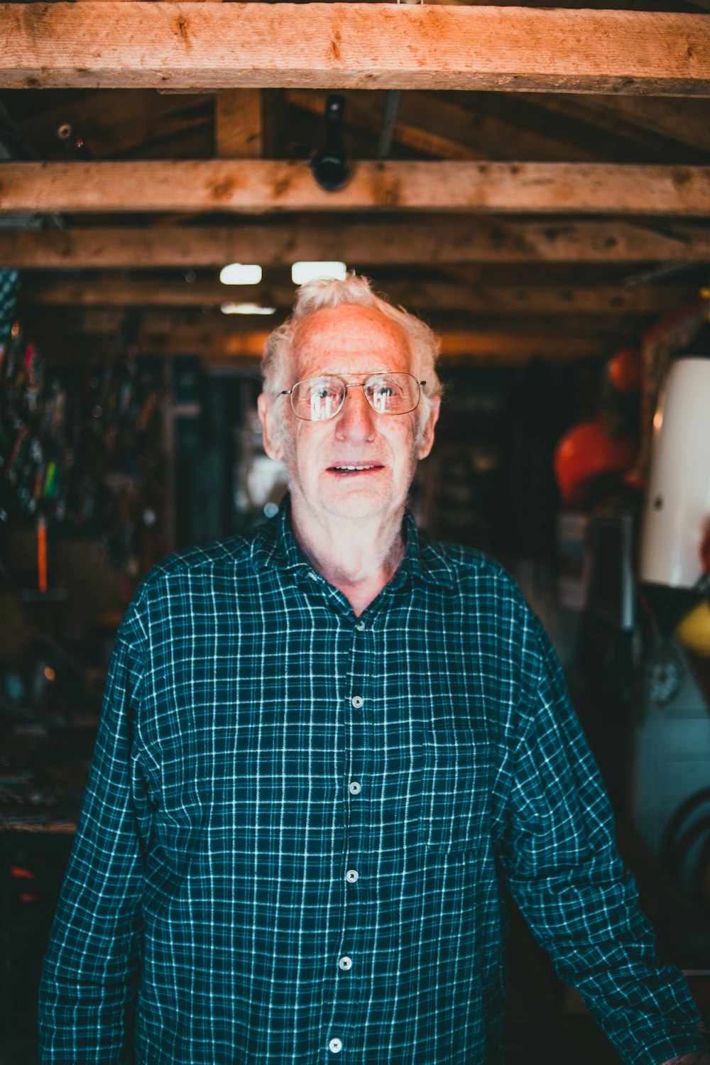 an older man standing in a garage with his hands on his hips