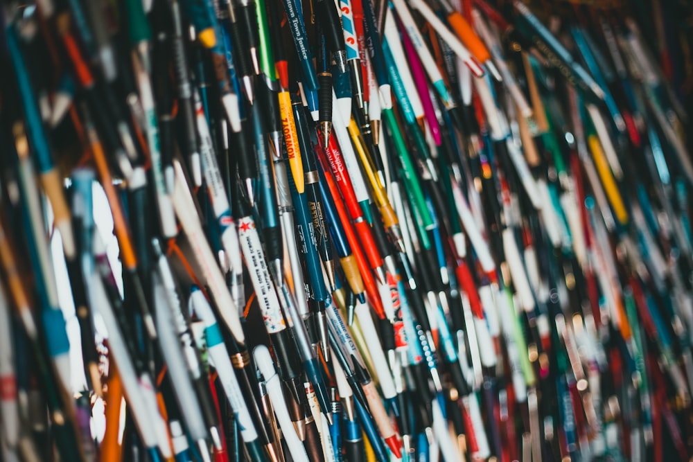 a bunch of different colored toothbrushes hanging on a wall