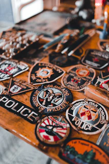a wooden table topped with lots of badges