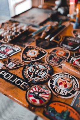 a wooden table topped with lots of badges