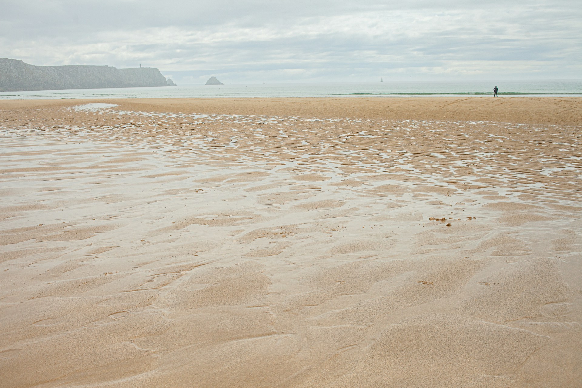 a sandy beach next to the ocean