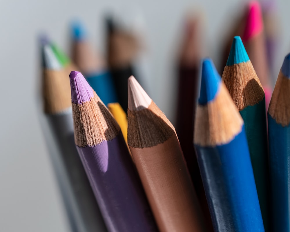 a group of colored pencils sitting next to each other