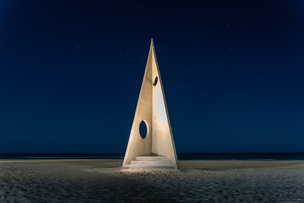 a very tall monument sitting on top of a sandy beach