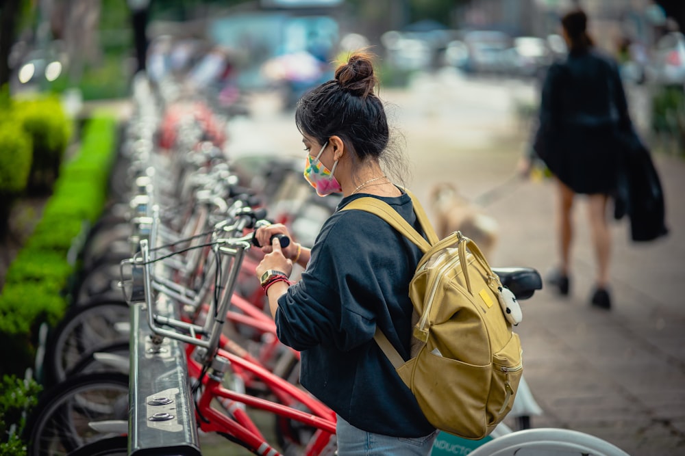 a woman standing next to a row of parked bikes