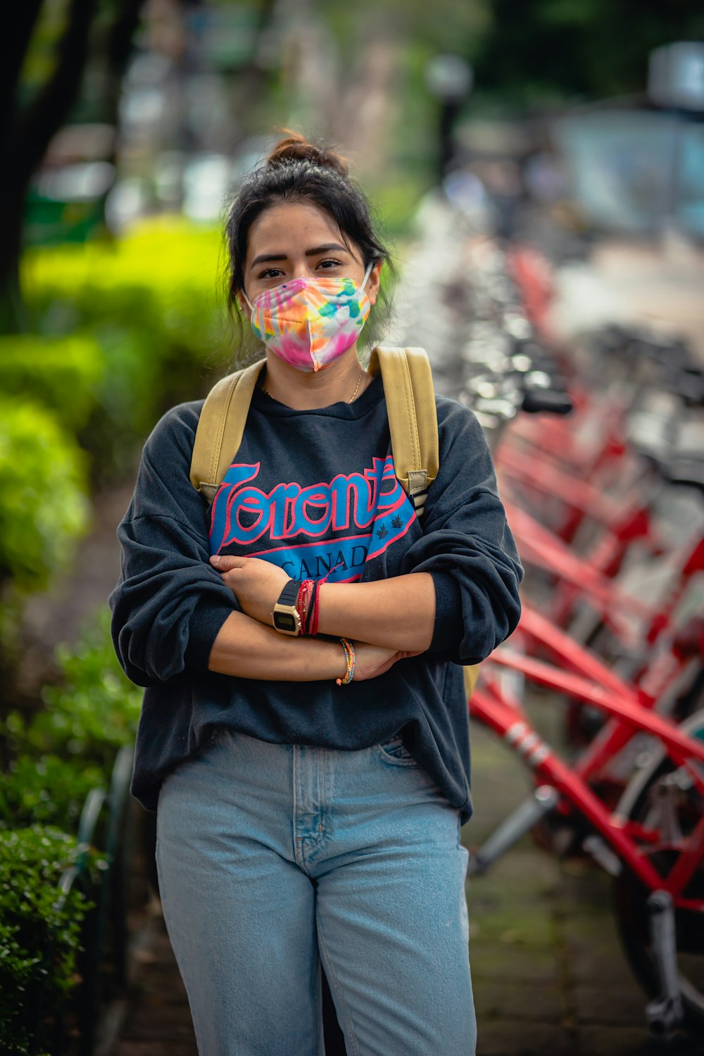 a woman wearing a mask standing in front of a row of bikes