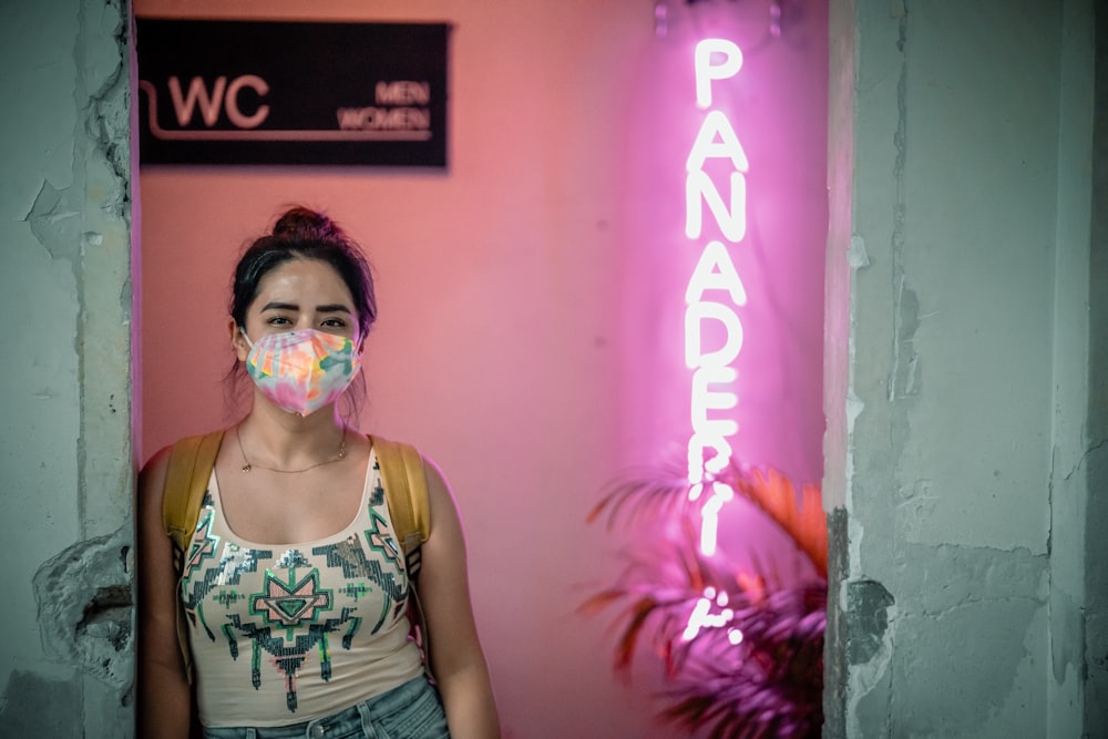 a woman standing in front of a neon sign