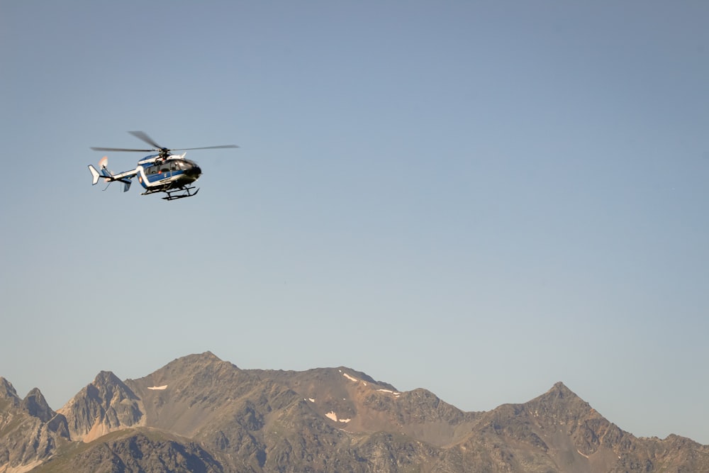 Ein Hubschrauber, der an klaren Tagen über eine Bergkette fliegt