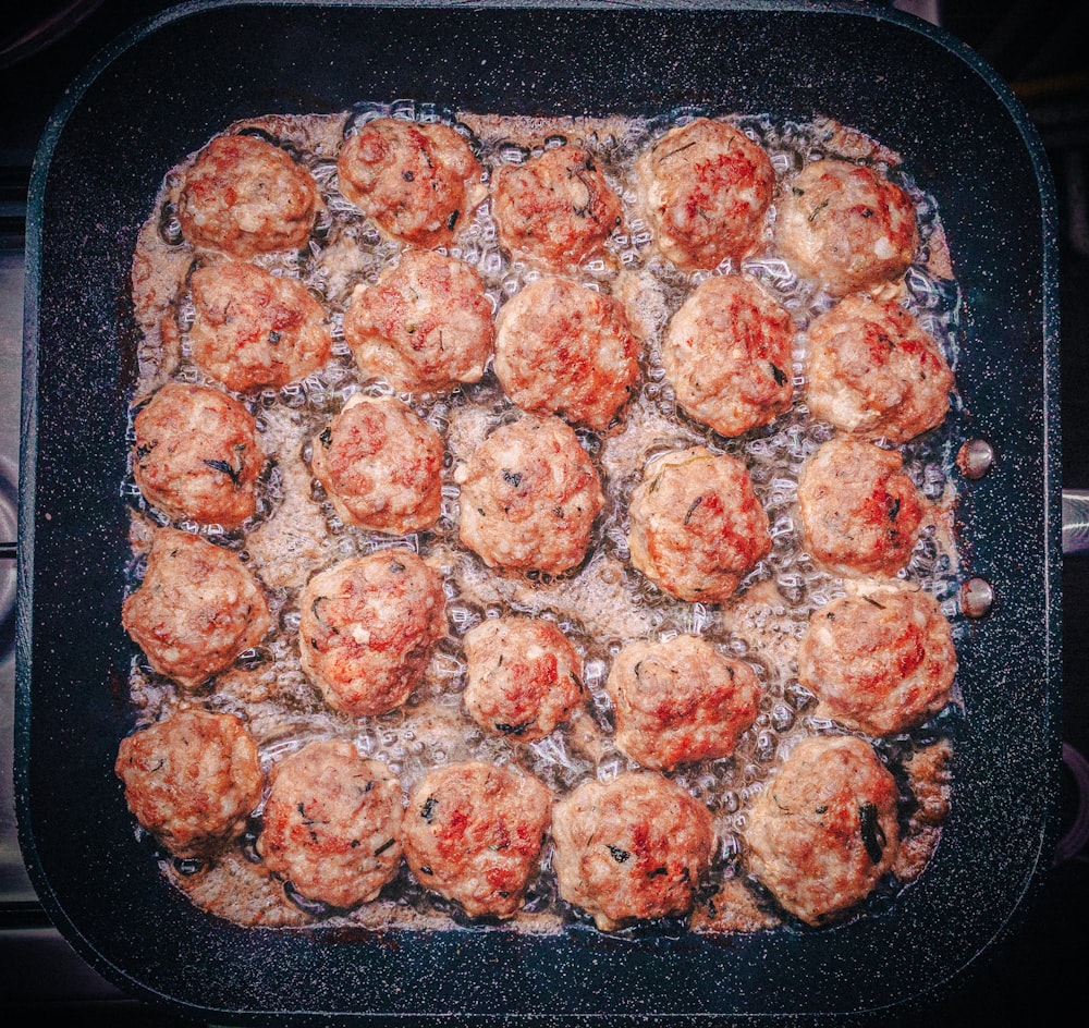 a pan filled with meatballs covered in sauce