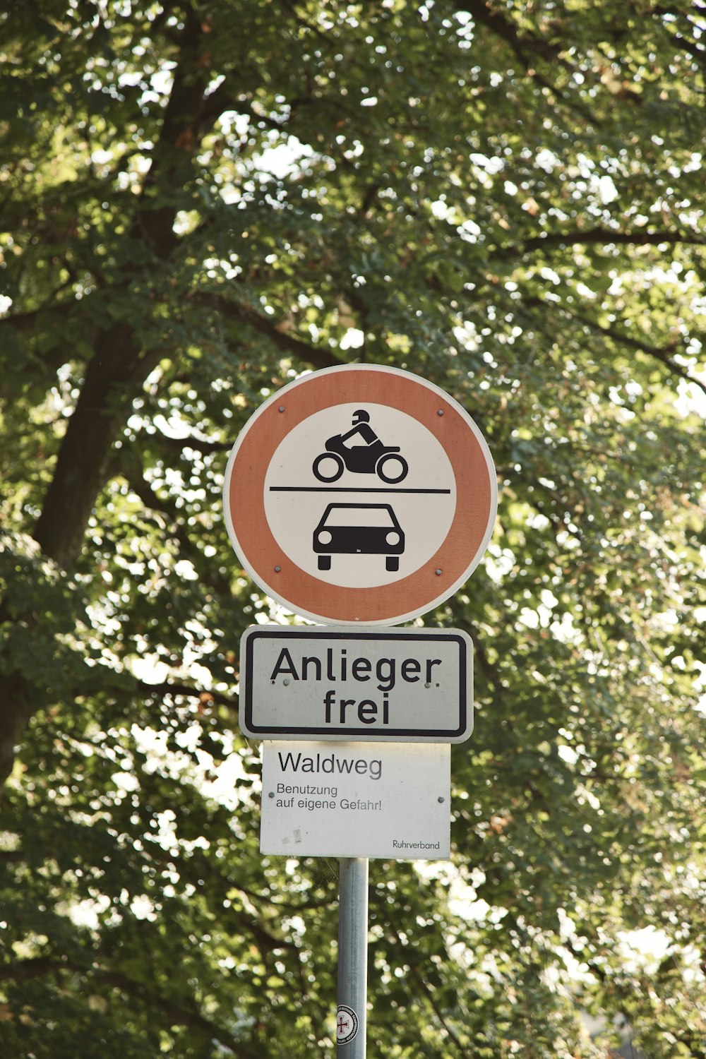 un panneau de signalisation avec des arbres en arrière-plan