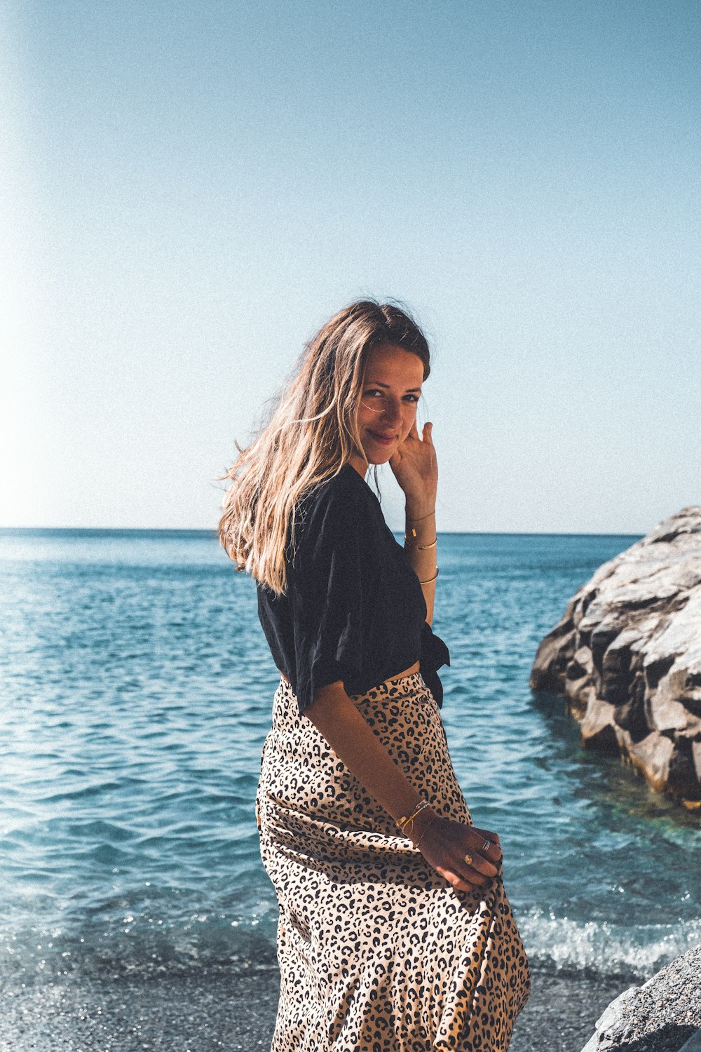 a woman standing on a beach next to the ocean