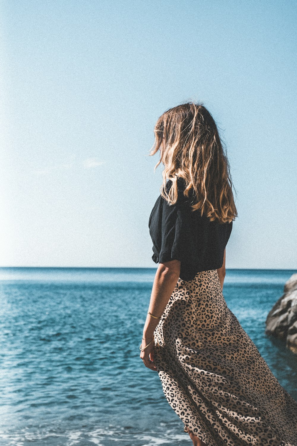 Une femme debout sur une plage au bord de l’océan