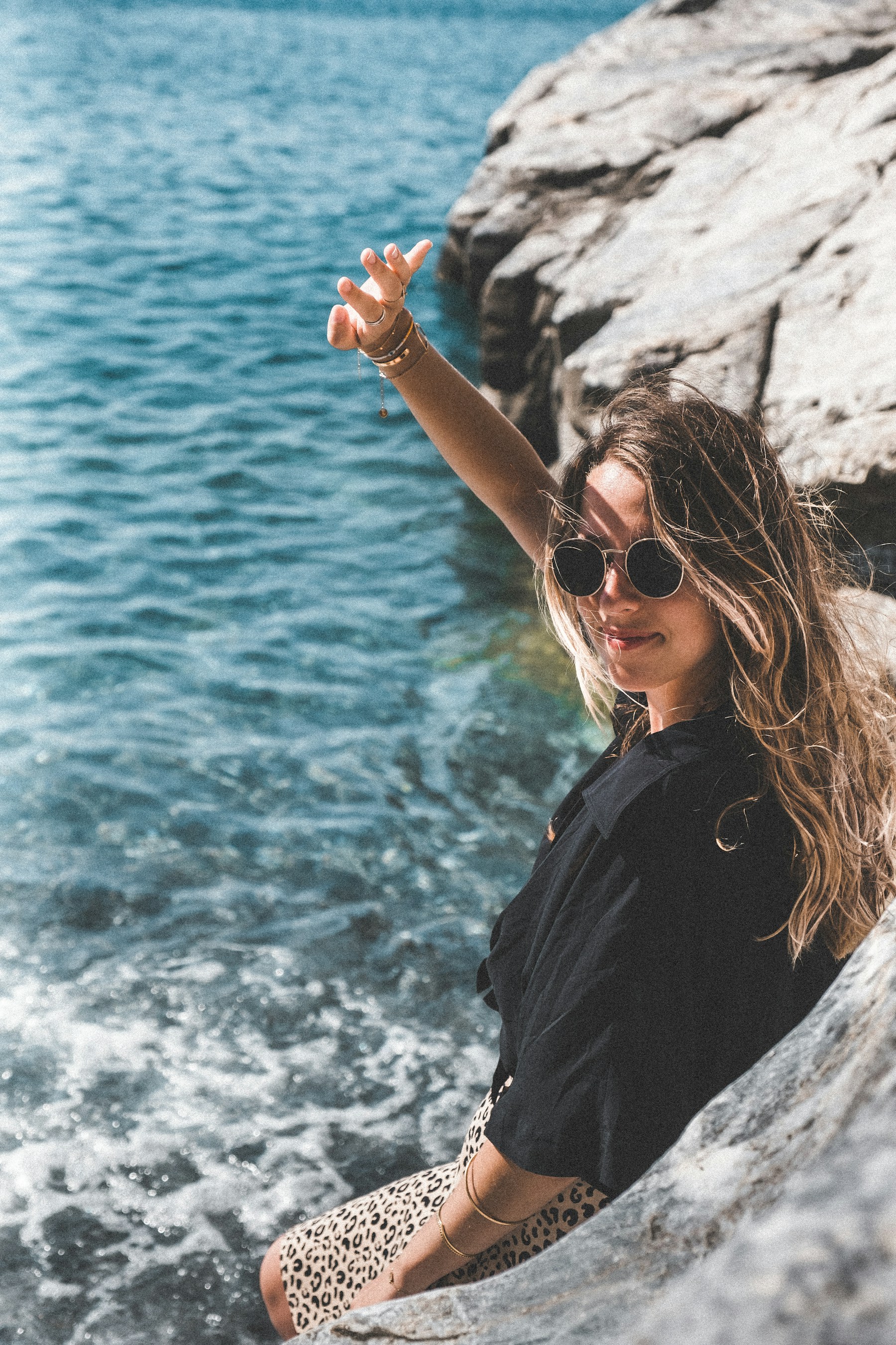 Modelo sobre rocas junto al mar — editorial moda costera