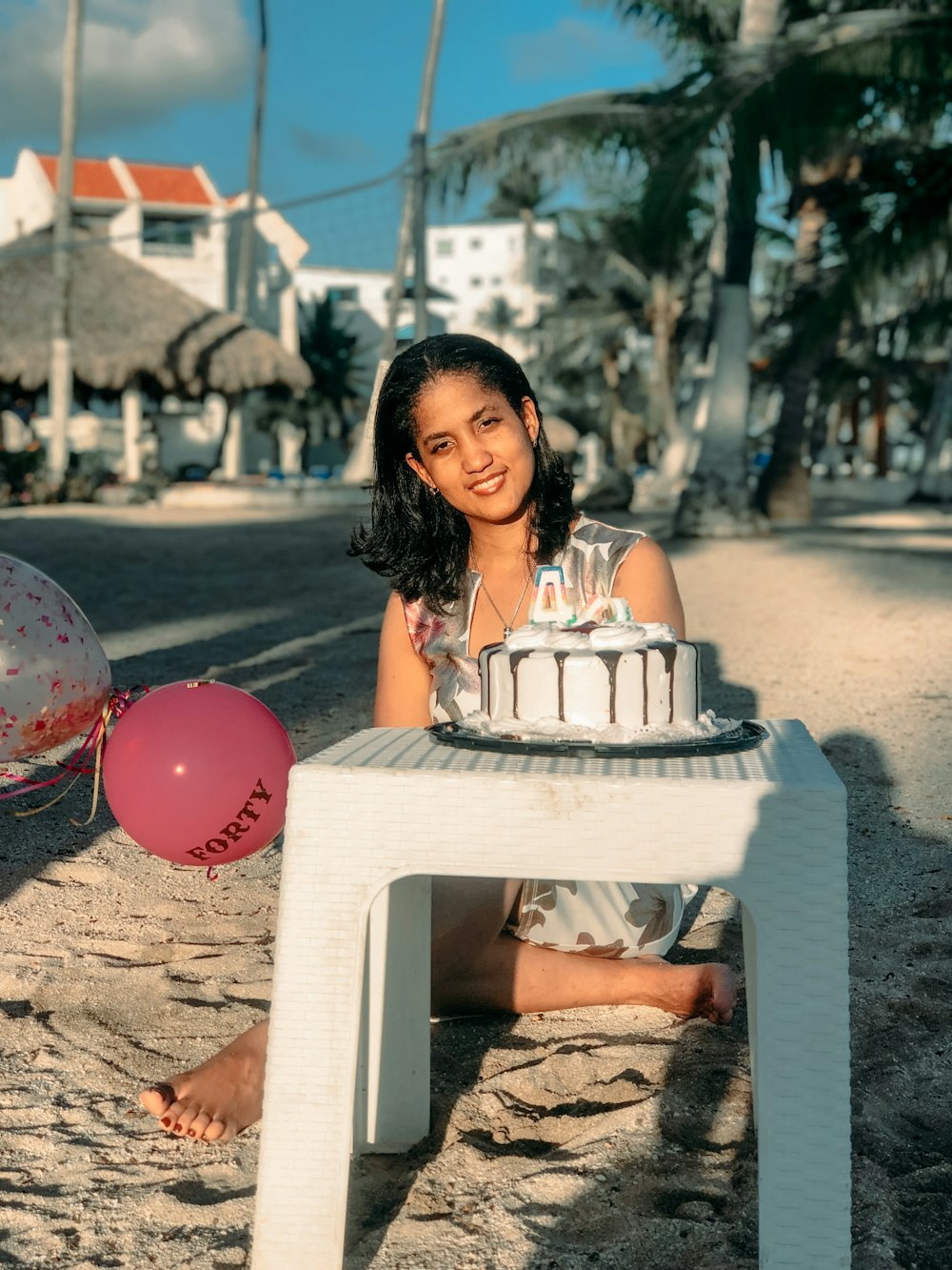 Une femme assise sur une plage avec un gâteau