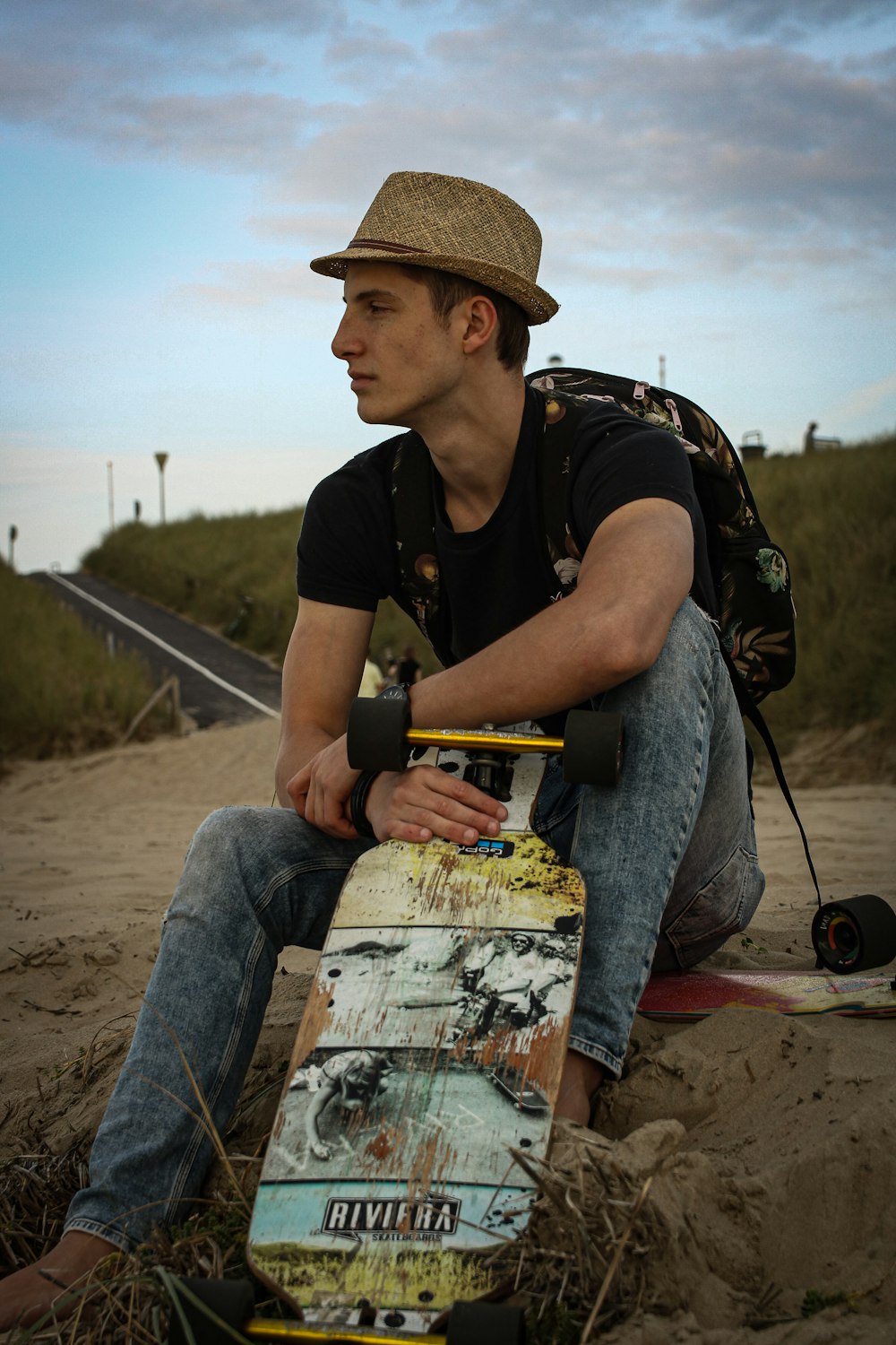 a man sitting on the ground with a skateboard