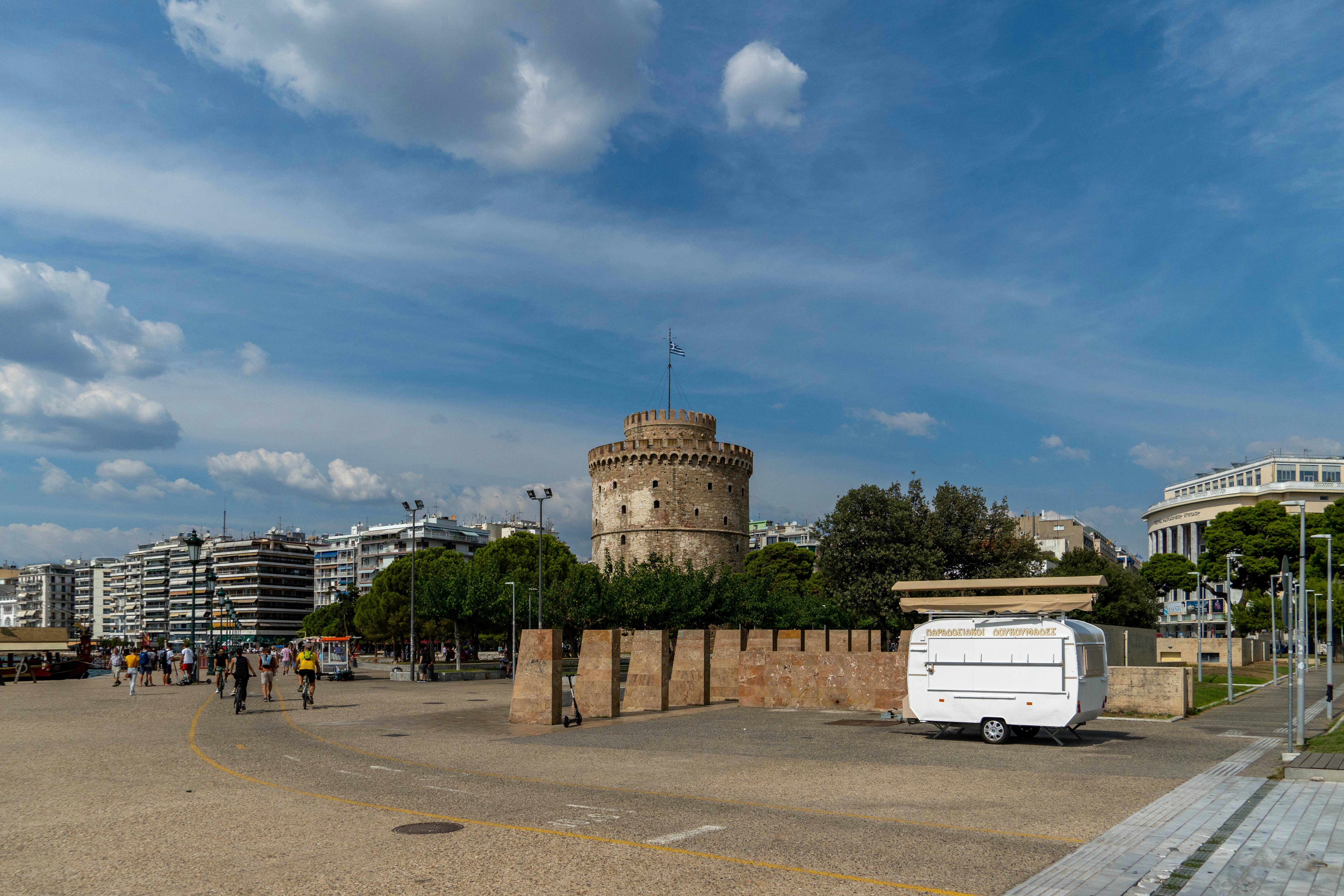 a white truck parked in a parking lot next to a tall tower
