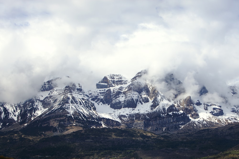 a mountain range covered in snow and clouds