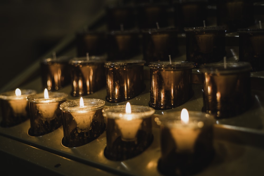 a row of lit candles sitting on top of a stove