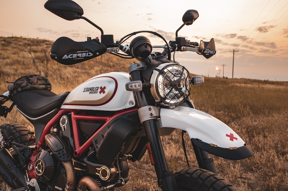 a white and red motorcycle parked in a field