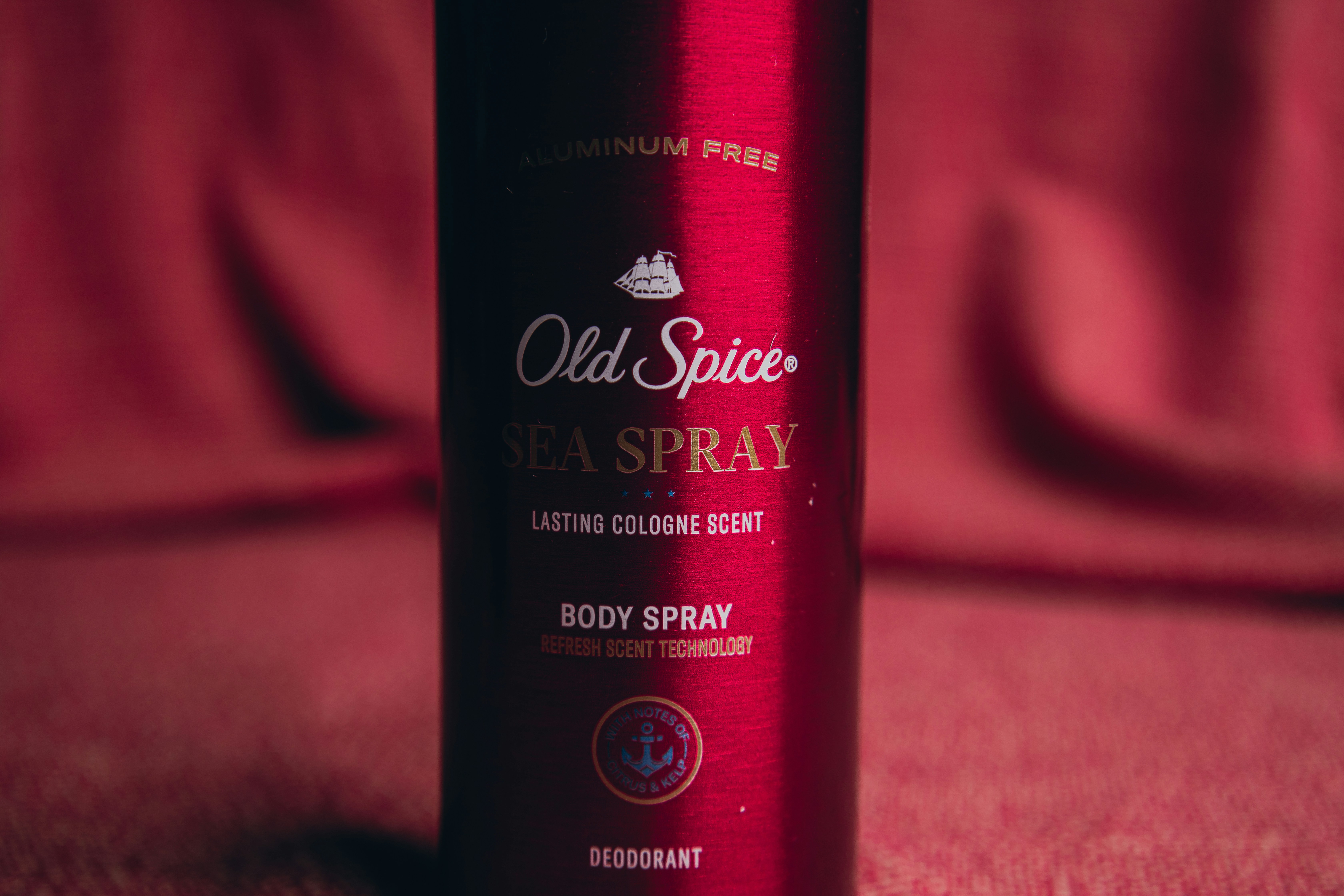 a bottle of old spice sea spray sitting on a bed