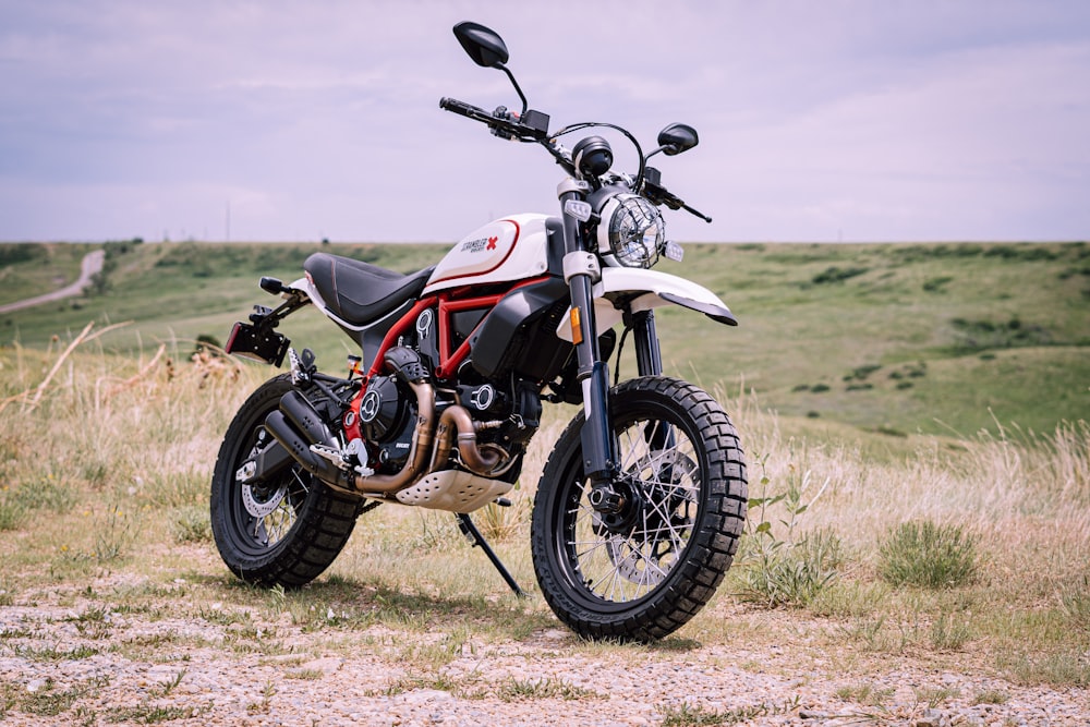 a motorcycle parked on a dirt road in a field