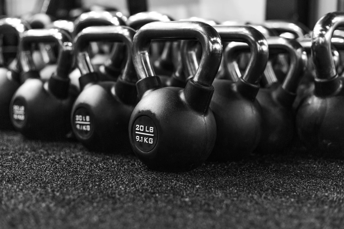 Real black kettlebells arranged on a strength training floor