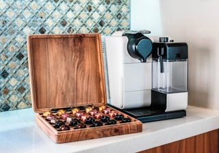 a coffee maker sitting on top of a counter next to a wooden box