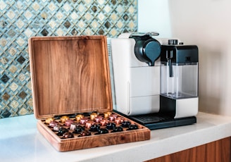 a coffee maker sitting on top of a counter next to a wooden box