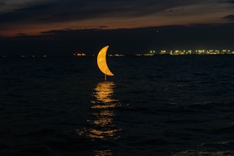 A glowing crescent moon rises over a futuristic cityscape glowing with neon blues and purples.