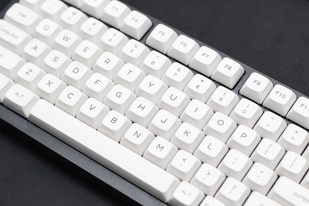a close up of a white keyboard on a black surface