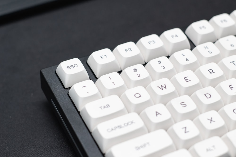 a close up of a white keyboard on a black surface