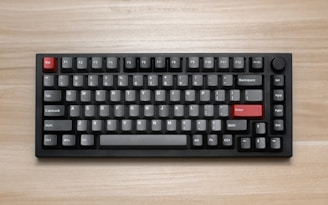 a computer keyboard sitting on top of a wooden table