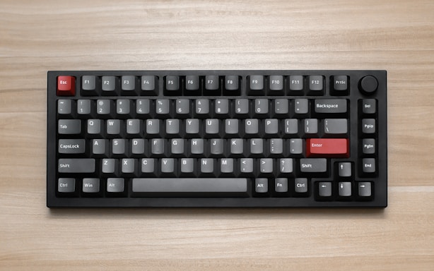 a computer keyboard sitting on top of a wooden table