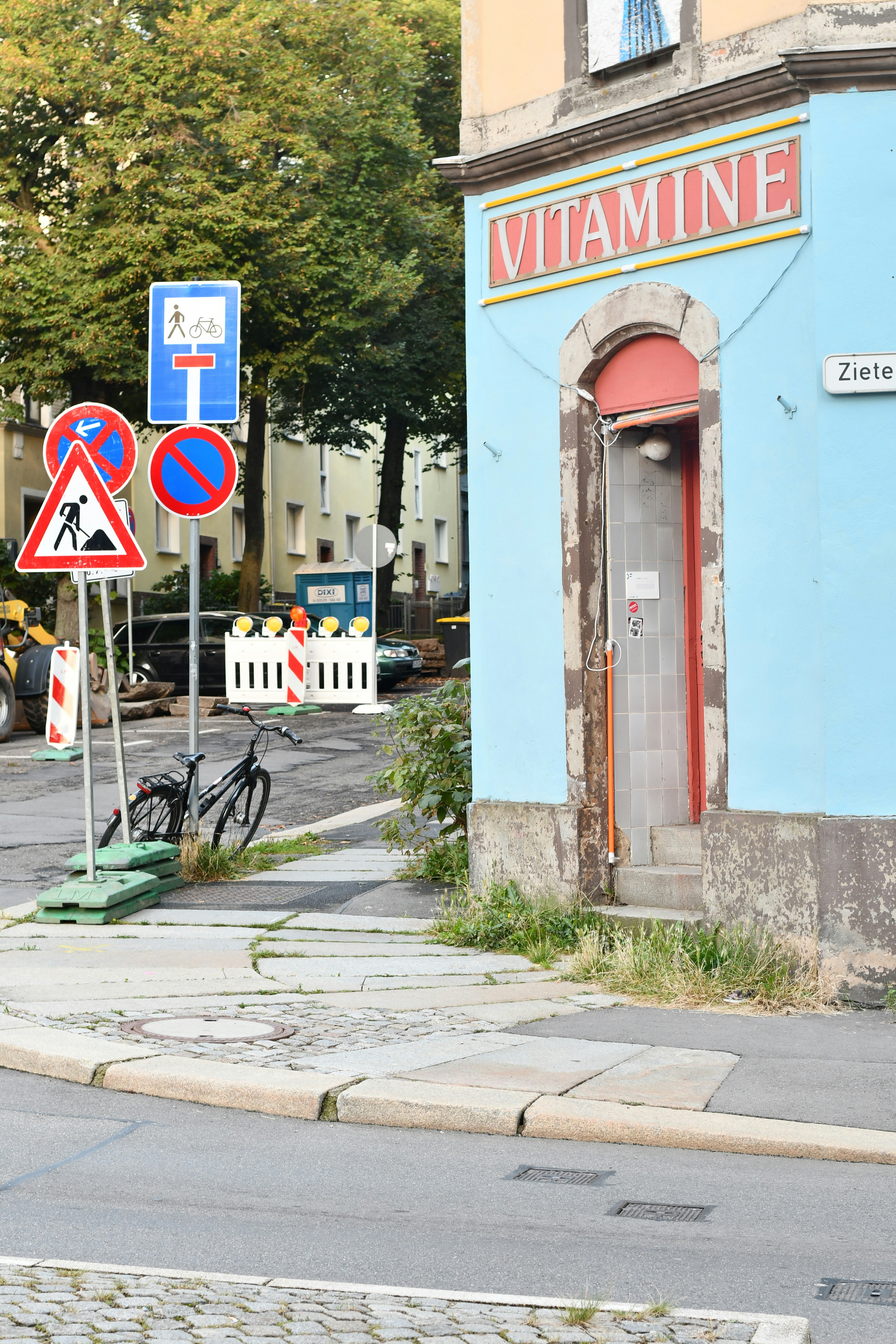 a street corner with a blue building and street signs