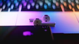 Lifestyle shot of a student using gadzhub airpods cover while working on a laptop with neon blue accents.
