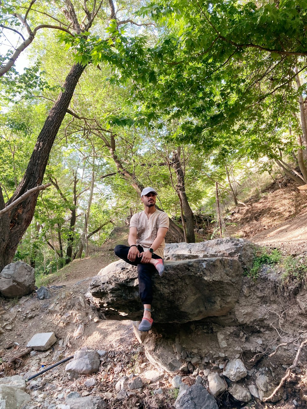 Ein Mann sitzt auf einem Felsen im Wald