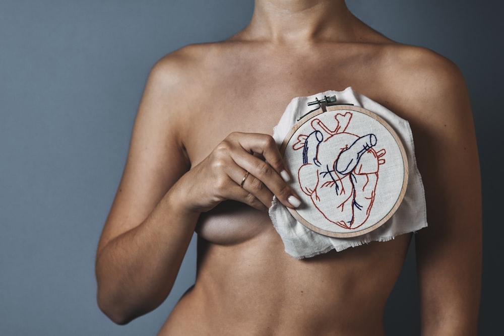 a woman holding a piece of cloth with a drawing on it