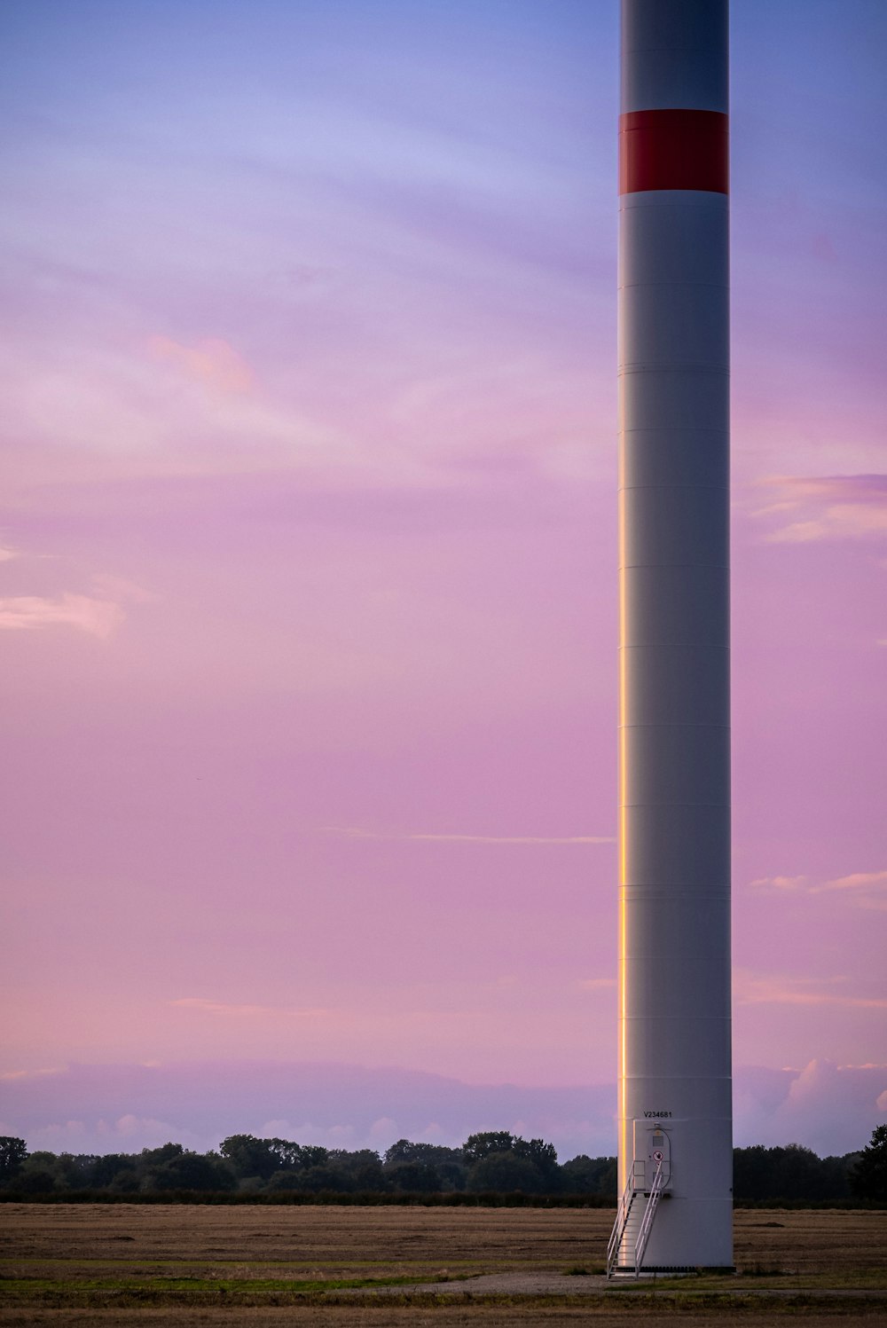 a large white tower sitting in the middle of a field