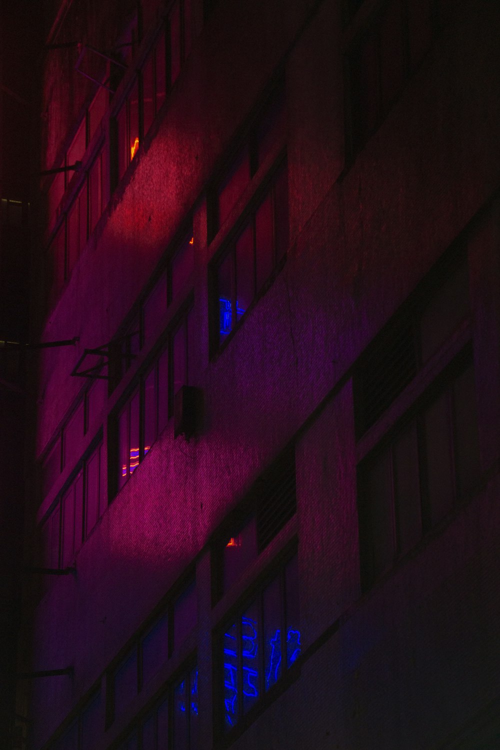 a tall building with a neon sign on the side of it