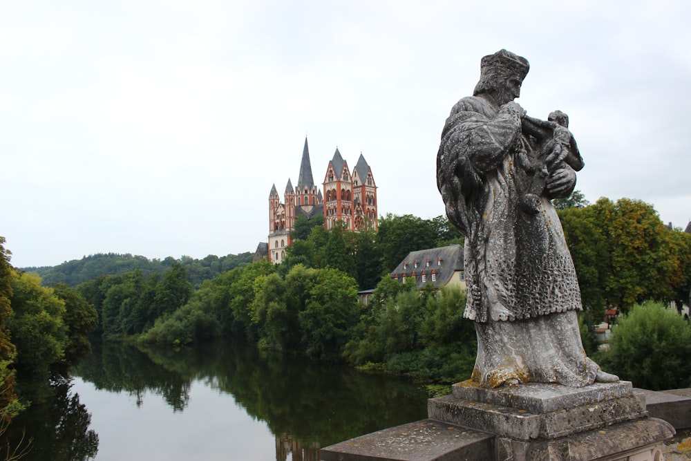 a statue of a man standing next to a river