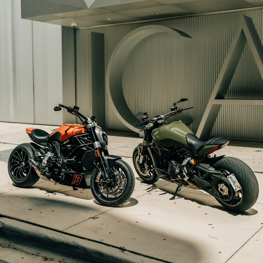 two motorcycles parked next to each other on a sidewalk