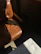 A sleek brown leather recliner chair beside a wooden side table with a lamp.