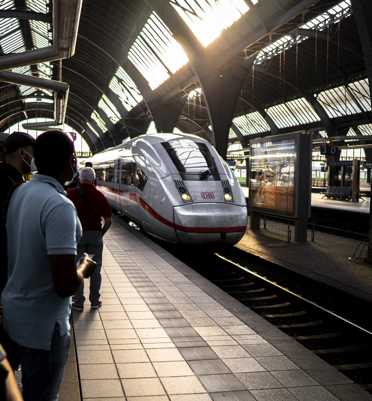 A white high-speed train pulling into a station platform