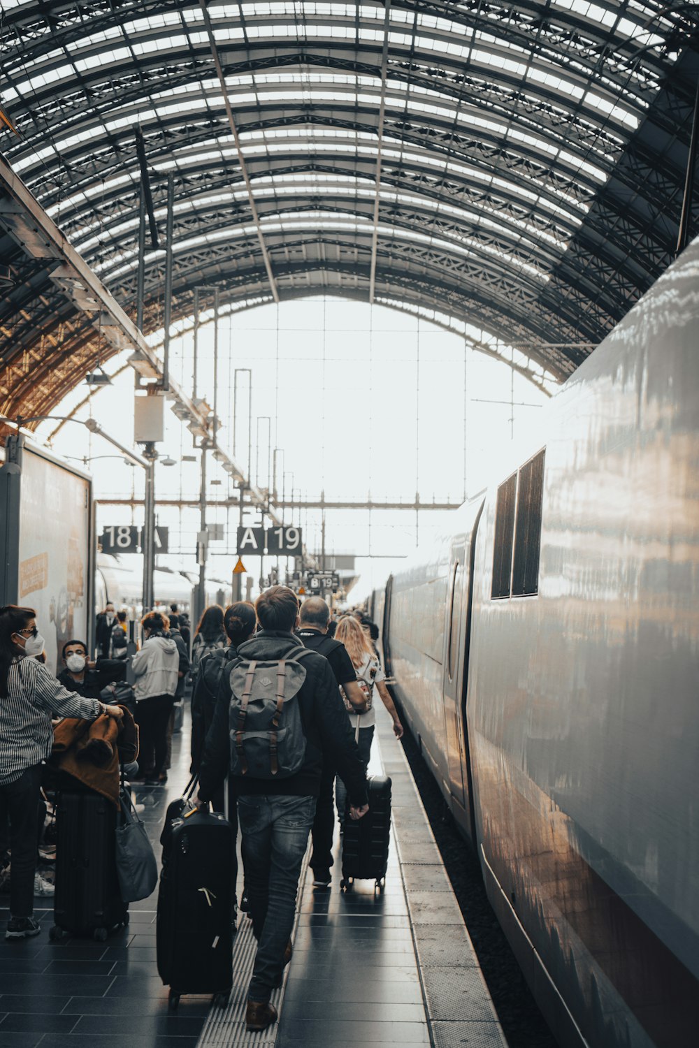 a group of people with luggage walking towards a train