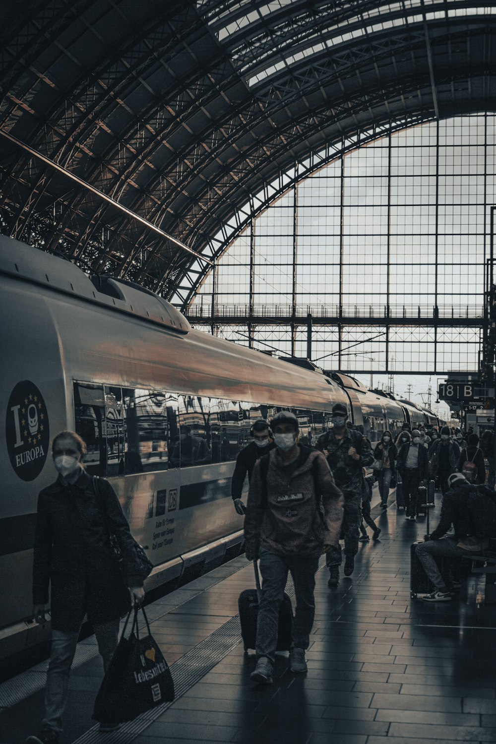 a group of people standing next to a train at a train station