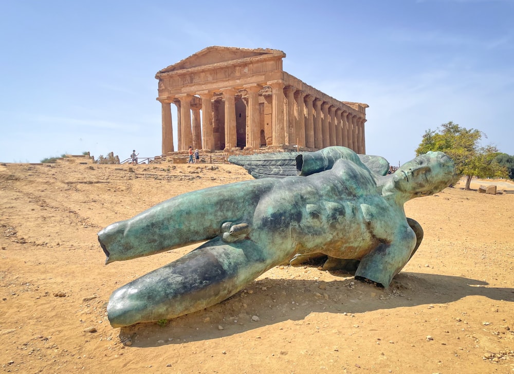 una statua di un orso che giace di fronte a un edificio